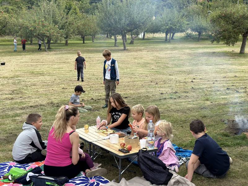 Děti u táborového stolu pod stromy