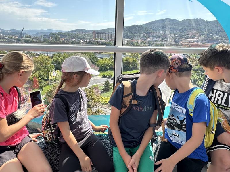 Děti pozorují krajinu z kabinky lanovky