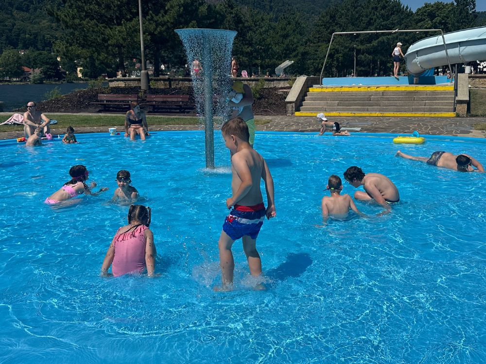 Děti u letního koupaliště s fontánou