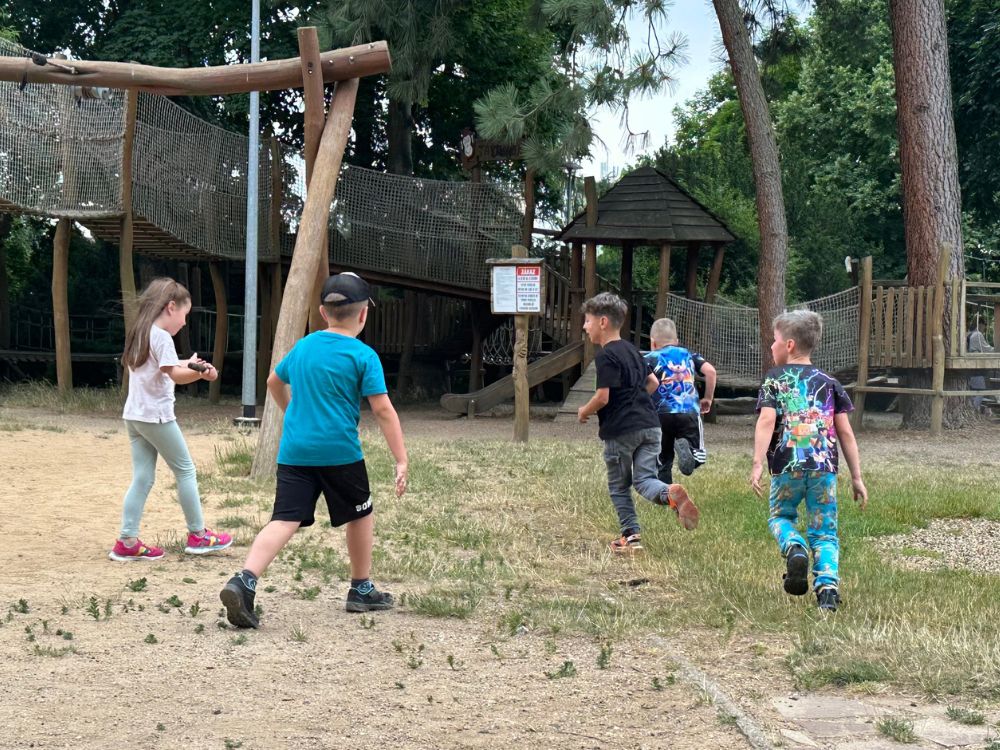 Děti běhají a hrají si na venkovním hřišti